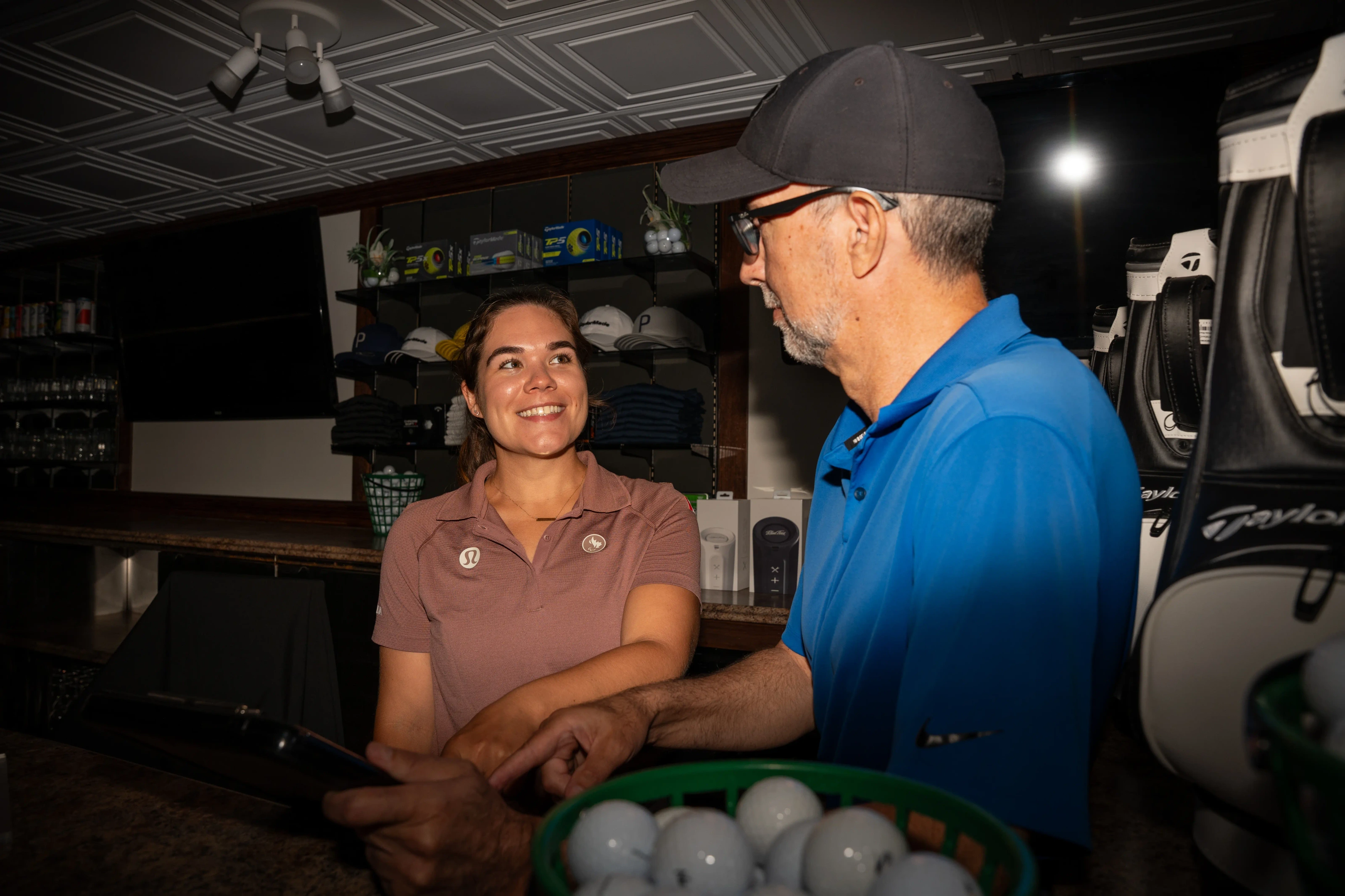 Golf club staff helping a golfer at the pro shop counter